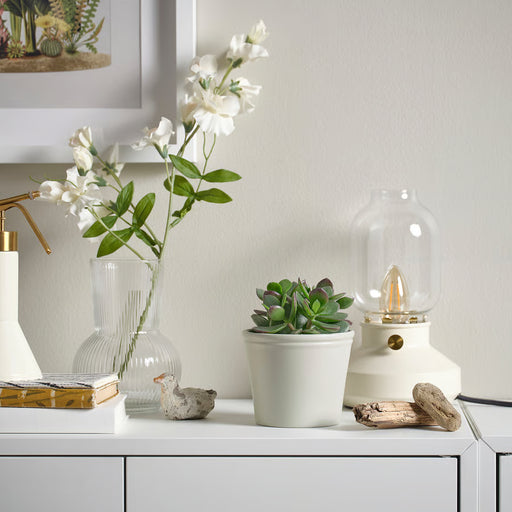  IKEA KÖRSBÄRSBJÖRK light grey-beige pot styled with flowering plant and lamp on white surface