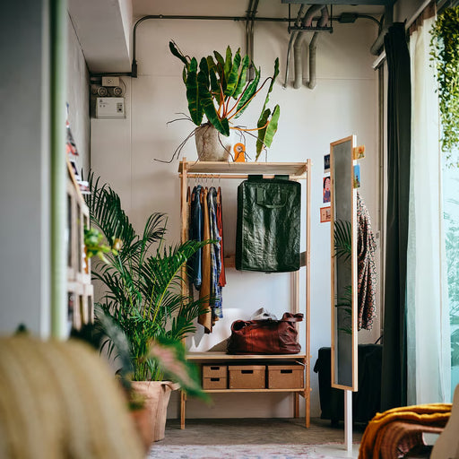 IKEA KOMPISHÄNG green storage bag hanging on wooden wardrobe rail with coats