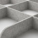Close-up of IKEA KOMPLEMENT light grey tray divider showing curved compartments and textured felt surface