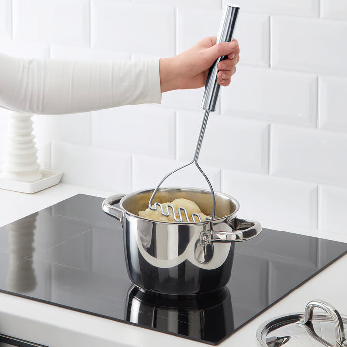 Person mashing potatoes on stovetop with IKEA KONCIS long-handle stainless steel masher
