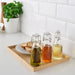 IKEA KORKEN glass bottles with stoppers on tray styled beside bread and indoor plant kitchen decor