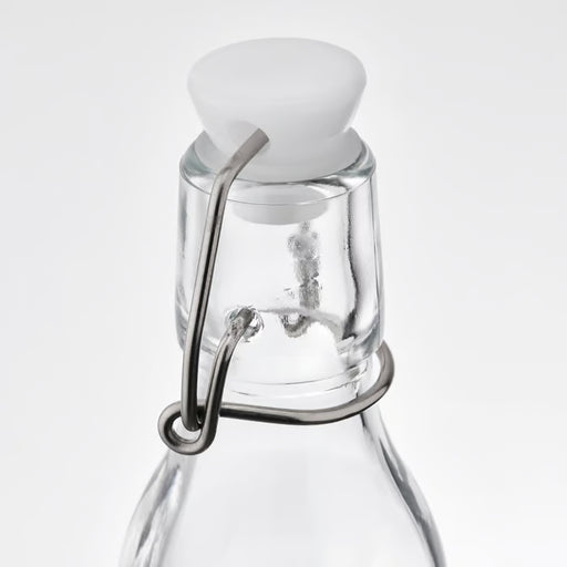 IKEA KORKEN clear glass bottle close-up showing white rubber stopper and stainless steel wire clasp