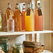IKEA KORKEN 1L clear glass bottle used for storing homemade drinks or condiments in a kitchen setting