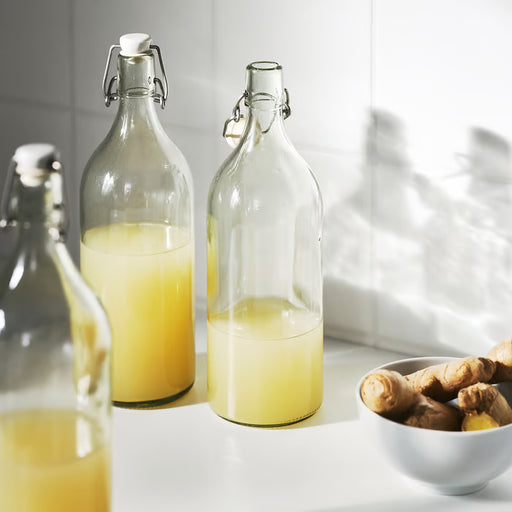  IKEA KORKEN 1L clear glass bottle with stopper styled on a kitchen counter with fresh beverages