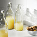  IKEA KORKEN 1L clear glass bottle with stopper styled on a kitchen counter with fresh beverages