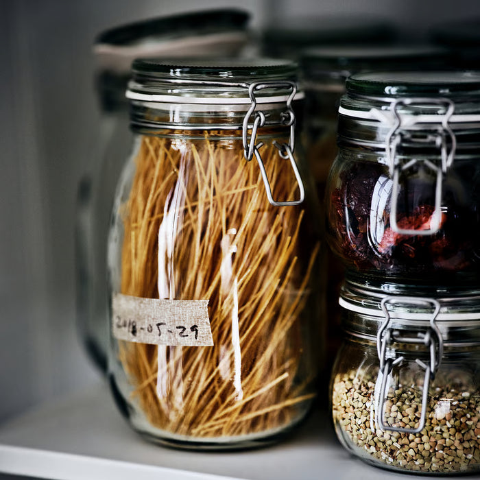 IKEA KORKEN jars in multiple sizes arranged on open pantry shelf with dry goods