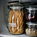 IKEA KORKEN jars in multiple sizes arranged on open pantry shelf with dry goods