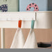 Two IKEA KRAMA white washcloths hanging on shelf with orange and green hanging straps