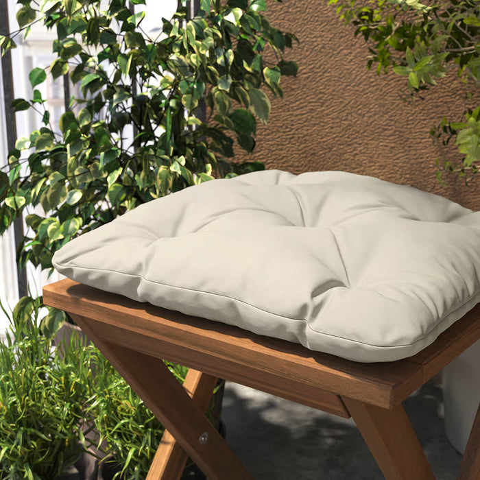 Close-up of IKEA KUDDARNA outdoor chair cushion light grey-beige showing fabric texture and reversible design