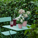 IKEA KVASTSPIREA pink plant pot styled with small green plant on a bright indoor shelf