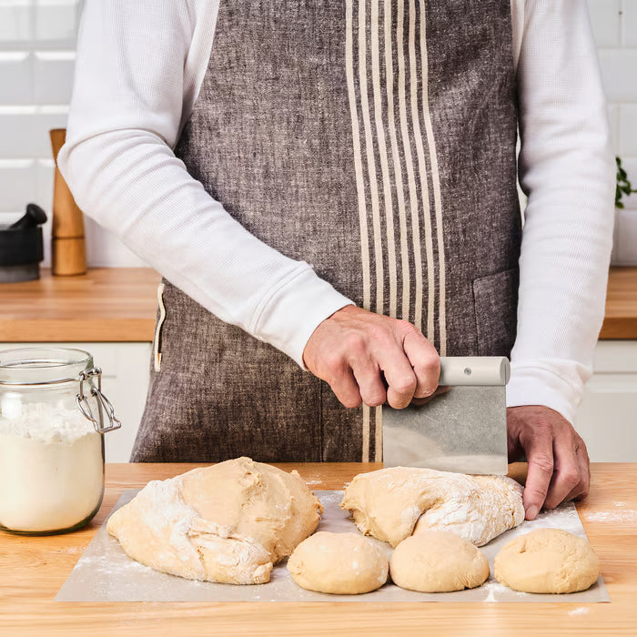 IKEA LÄTTBAKAD metal dough scraper lifting flour-covered dough on kitchen counter