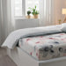  IKEA LAPPNYCKLAR flat sheet with pink and grey floral print folded on white bed