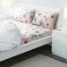 IKEA LAPPNYCKLAR multicolour floral bed linen set styled on white bed with white comforter and bedside lamp