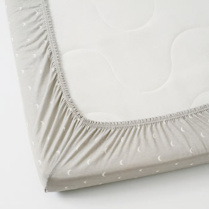 IKEA LENAST fitted sheet on baby cot mattress showing elastic edges

