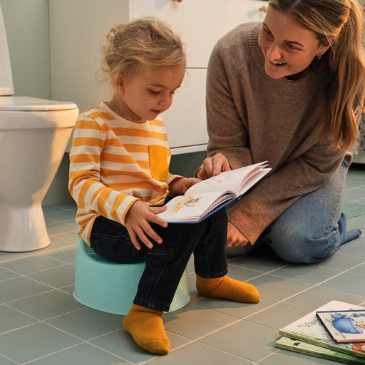 Bright turquoise children's training potty with ergonomic design, non-slip base, and removable splash guard for easy cleaning