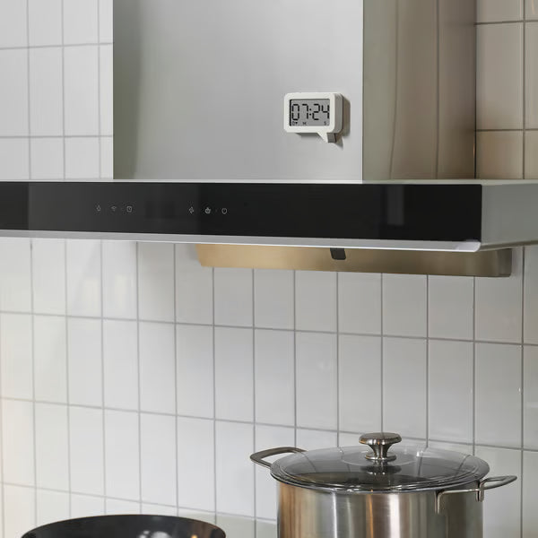  IKEA LJUNGPIPARE white magnetic digital clock mounted on kitchen fridge beside large cooking pot