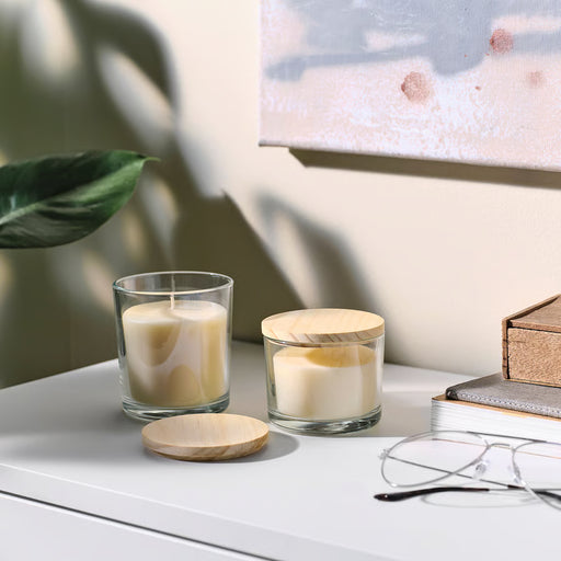 IKEA LOTSFÅGEL pine lid for scented candle placed on a glass candle
