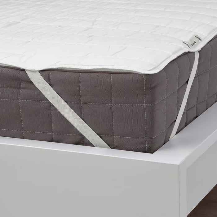  IKEA LUDDROS white mattress protector with elastic corner straps secured on bed frame close-up