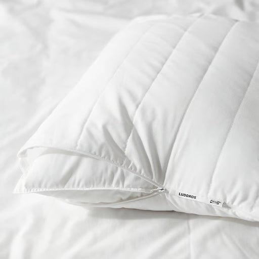 IKEA LUDDROS white pillow protector with zip closure on white bed