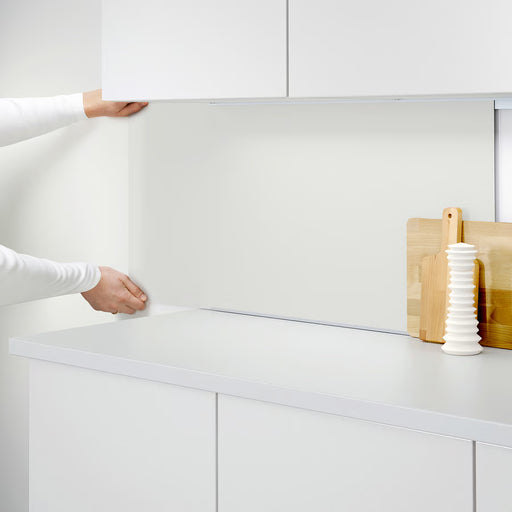 Person fitting IKEA LYSEKIL wall panel onto kitchen cabinet using rail