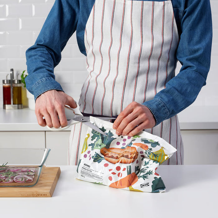  Person using IKEA MÄRKBART scissors to cut open a bag in a kitchen while holding glass containers
