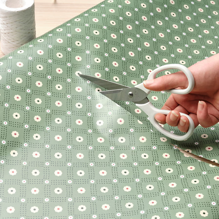 Person cutting green patterned paper with IKEA MÄRKBART scissors craft use close-up
