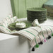IKEA MÄVINN green stoneware plate on striped tasseled cloth with stacked plates