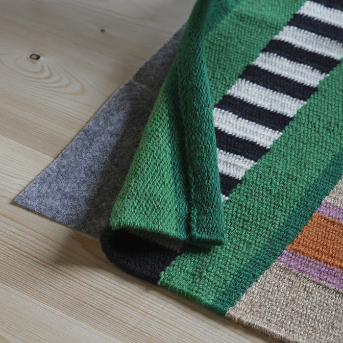 IKEA MÄVINN rug folded view green black white multicoloured stripe pattern on wooden floor