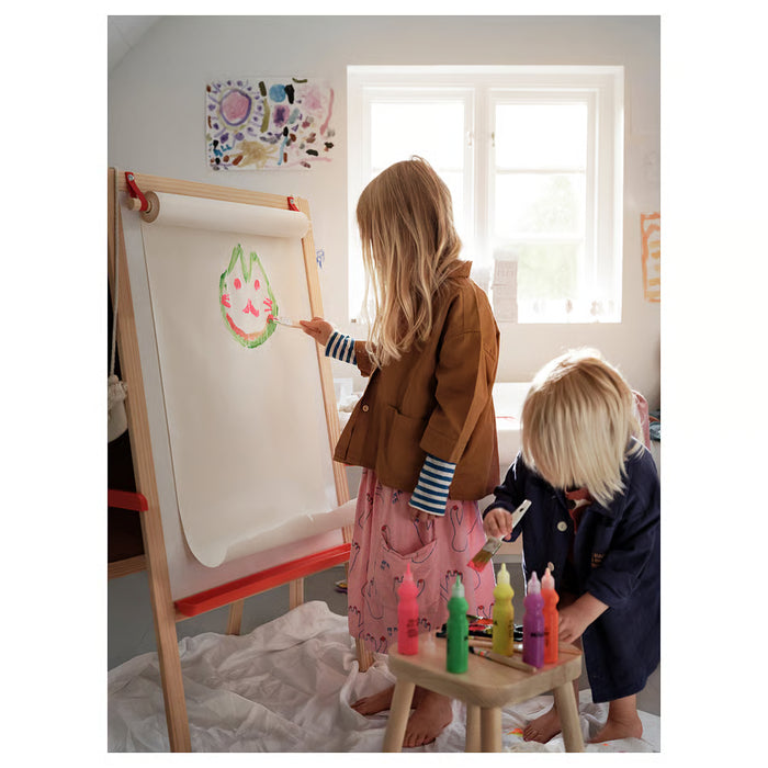  Two kids painting together at an easel using IKEA MÅLA brushes and paints
