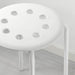 Close-up of IKEA MARIUS white stool round perforated seat and powder-coated leg detail