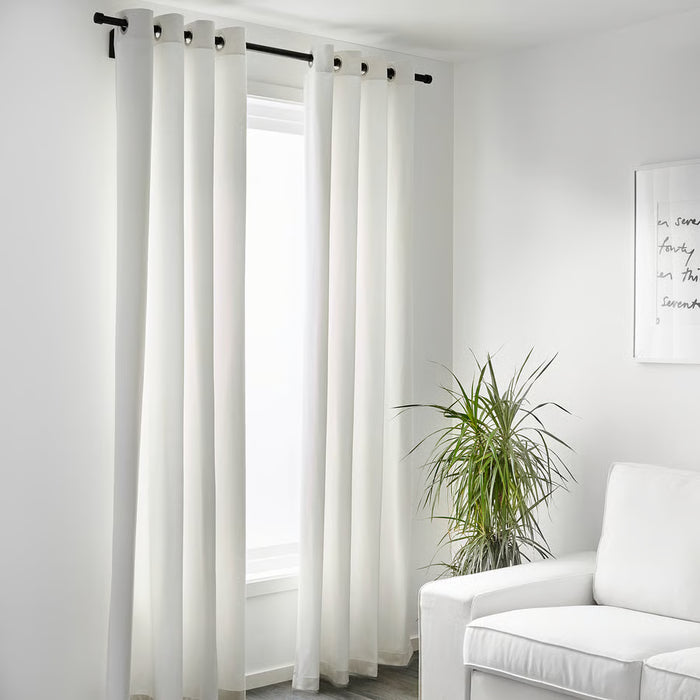 IKEA MERETE white room darkening curtains in minimalist living room with plant and chair