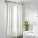 IKEA MERETE white room darkening curtains in minimalist living room with plant and chair