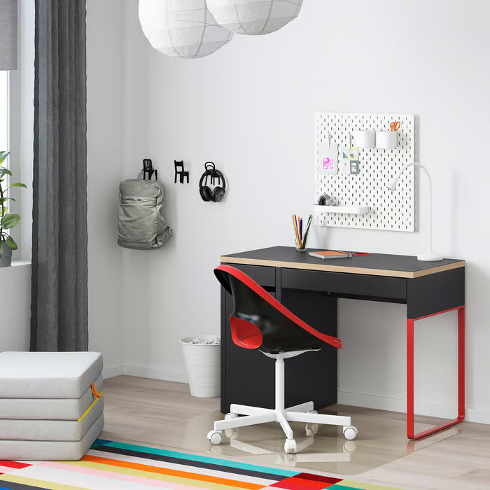 IKEA MICKE anthracite red desk in modern home study setup with red chair and pegboard wall organiser