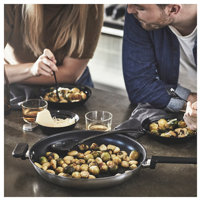 Two people dining with roasted brussels sprouts cooked in IKEA MIDDAGSMAT pans