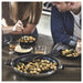 Two people dining with roasted brussels sprouts cooked in IKEA MIDDAGSMAT pans