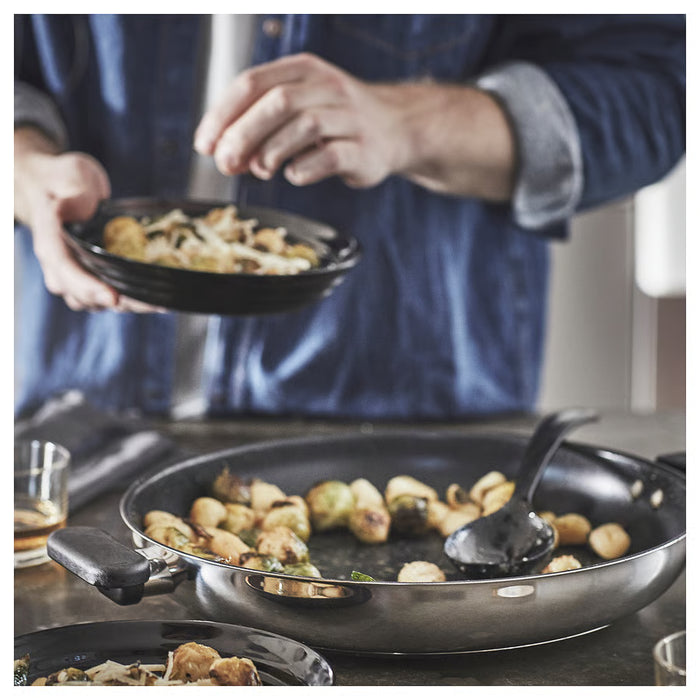 Home cook stirring food in IKEA MIDDAGSMAT frying pan on stovetop