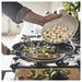 Adding dumplings to IKEA MIDDAGSMAT frying pan alongside brussels sprouts