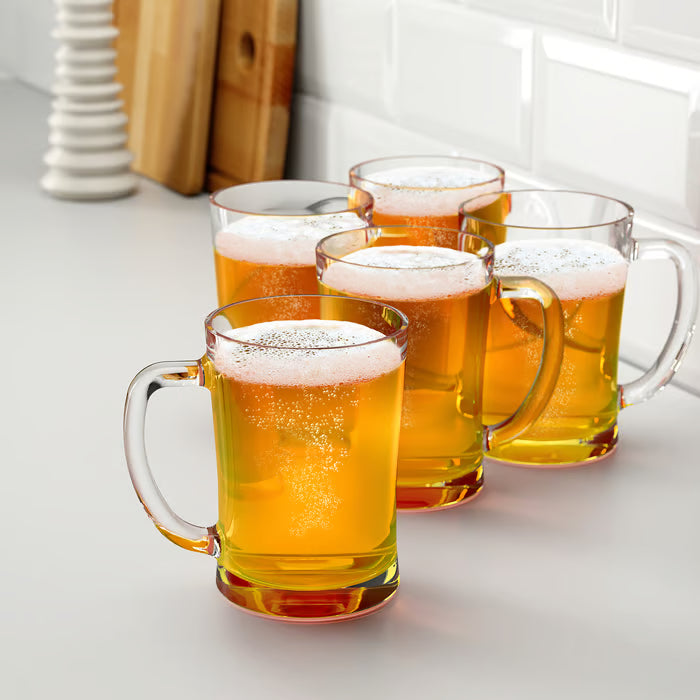 Four IKEA MJÖD beer tankards with frothy beer lined up on a countertop