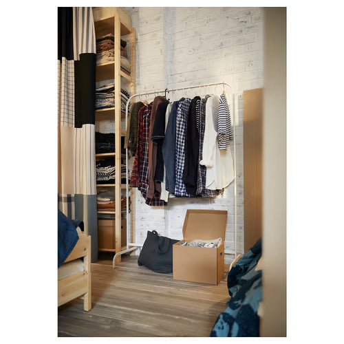  IKEA MULIG white clothes rack styled with assorted hanging clothes against white brick wall