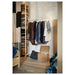  IKEA MULIG white clothes rack styled with assorted hanging clothes against white brick wall