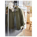  IKEA MULIG white garment rack with jacket, sweater, and cap hanging beside a mirror