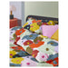 IKEA MURREVA duvet cover styled on a bed in a bright bedroom with coordinating cushions