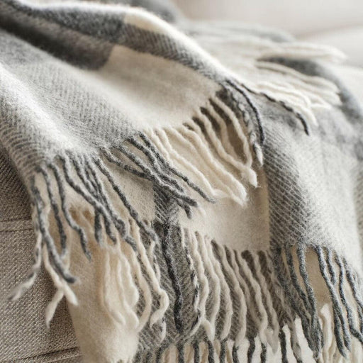 Close-up of IKEA MYRULL light grey wool throw showing brushed texture and dark stripe fringe detail