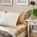  Neatly made bed with IKEA NÄSSELKLOCKA floral bedding, throw and bedside decor