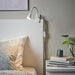 IKEA NÄVLINGE white LED clamp lamp on bookshelf illuminating books and decorative sphere