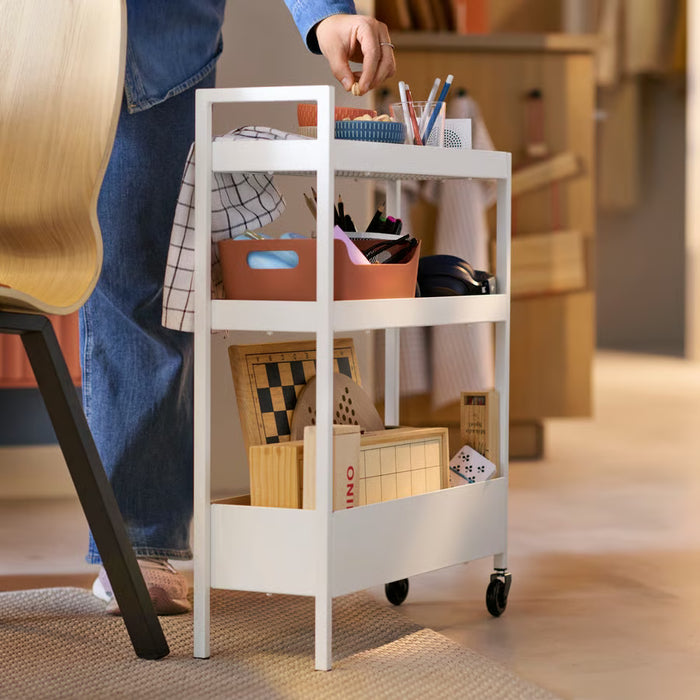 IKEA NISSAFORS white trolley placed beside armchair with accessories
