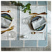 IKEA NISSÖGA blue tablecloth set on dining table with plates, cutlery and glasses