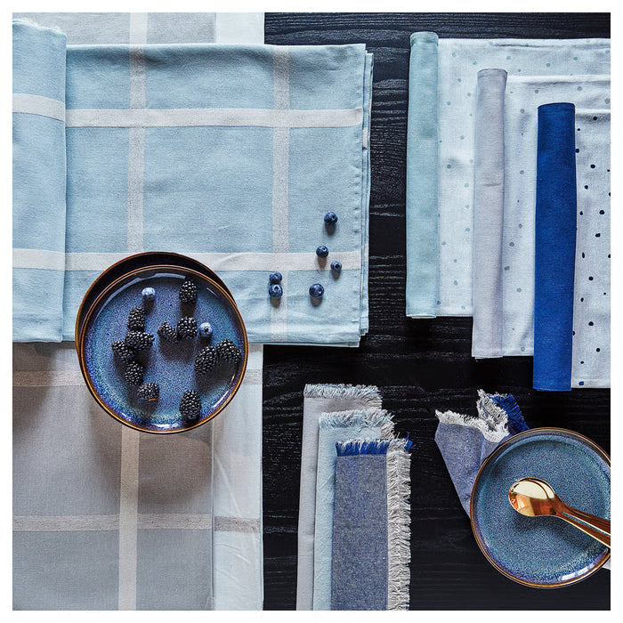 IKEA NISSÖGA blue tablecloth on table with blackberries, spoons and napkins