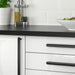 IKEA NYDALA black handles fitted on white kitchen drawers, modern setting