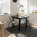 IKEA NYMÅNE white pendant lamp hanging above modern dining table with chairs in minimalist room